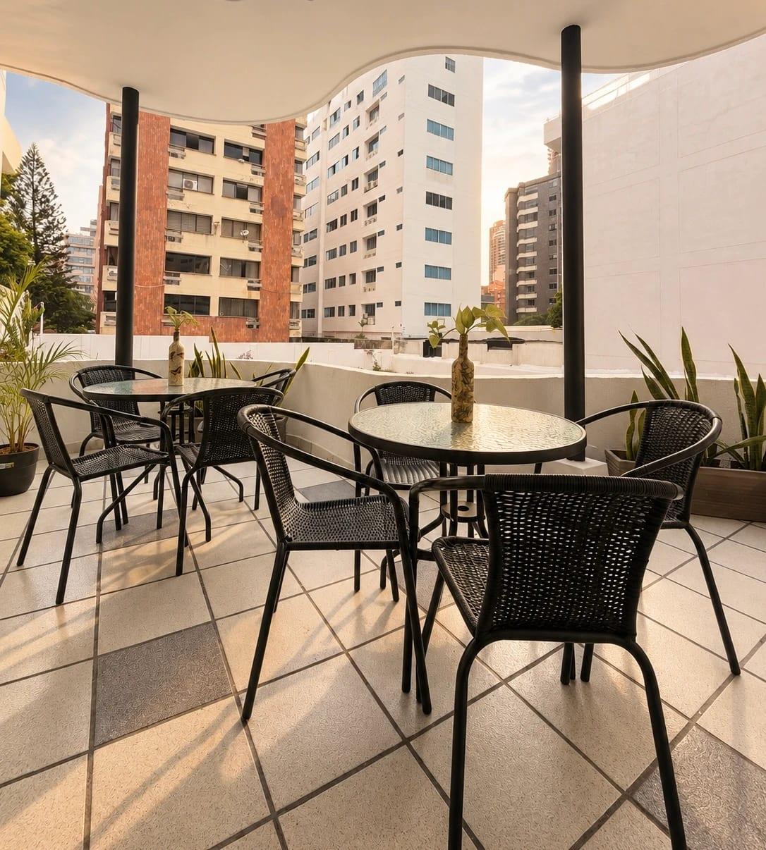 Outdoor terrace with tables and woven chairs