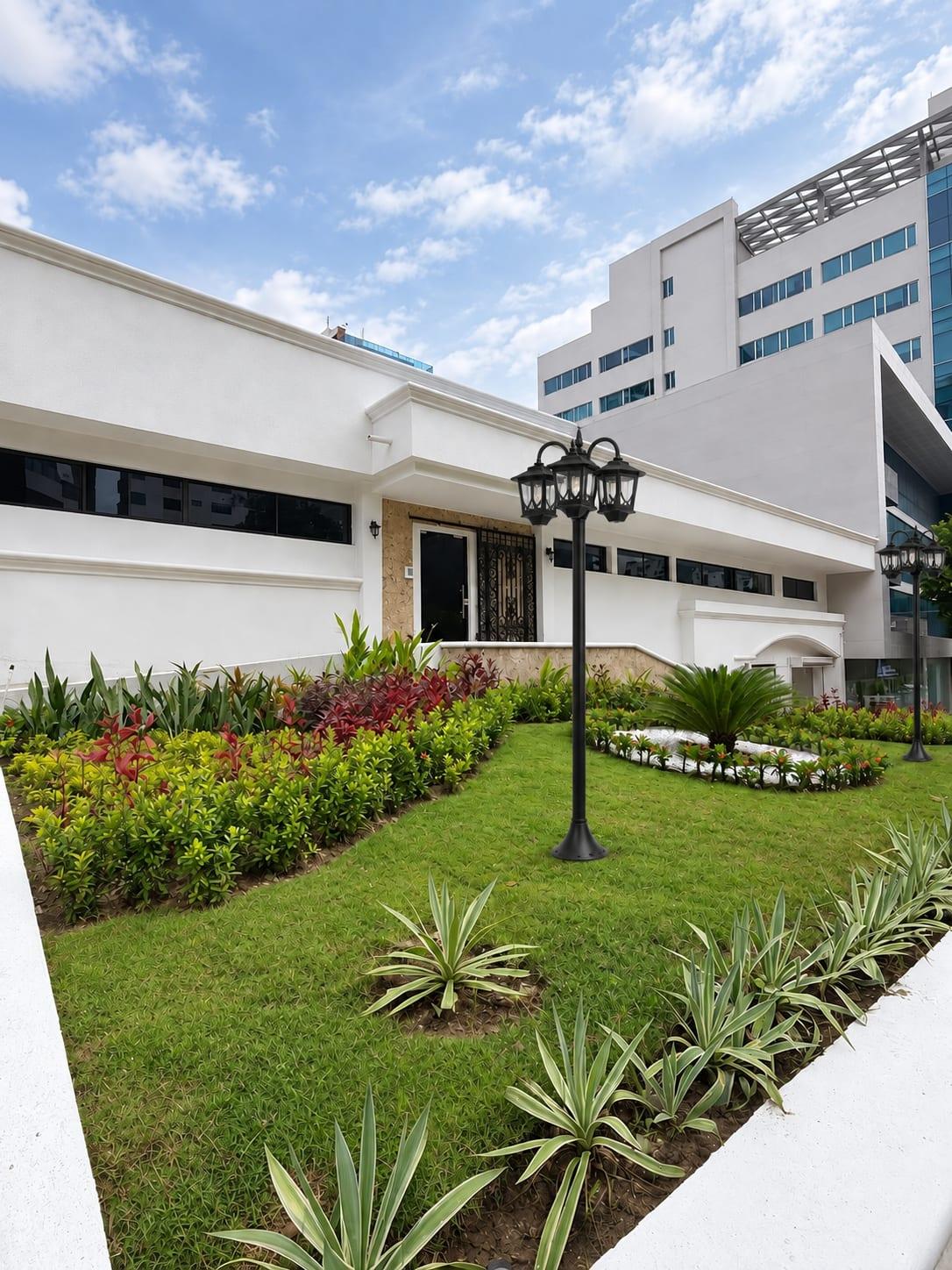 Casa 53 white façade with garden and lampposts